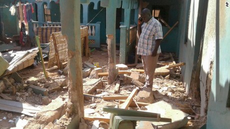 A man stands amid the debris at the scene of an attack in the town of Mandera, Kenya.