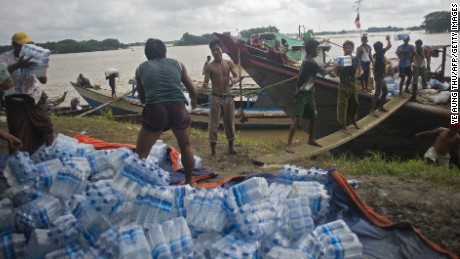 Volunteers load food supplies onto boats for flood-affected residents in Myanmar&#39;s Irrawaddy region in August 2015. 