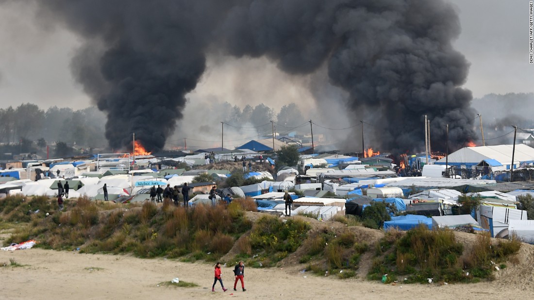 Smoke rises from multiple fires blazing in the camp on Wednesday, October 26, as French authorities work to demolish the settlement and evacuate its residents to reception centers around France.