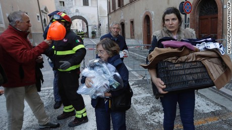 Residents carry some of their belongings after part of Visso was destroyed. 