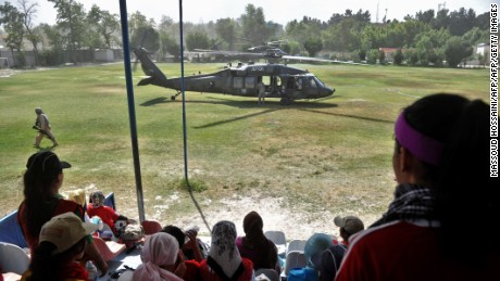  Afghanistan&#39;s women&#39;s national football team members take a break from training as a US Black Hawk helicopter lands.