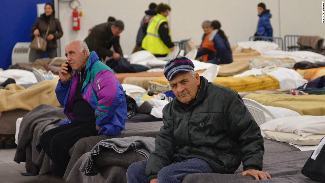 Residents from the village of Caldarola prepare to spend the night in an emergency camp set up in a warehouse on October 30.