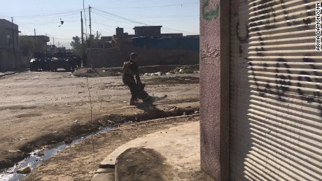 Two soldiers drag a wounded man across a road. The man was fired upon after driving a taxi toward the troops. The man later died.