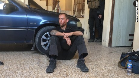 Brice sits with a head injury at a civilian house after their MRAP (Mine-Resistant Ambush Protected) vehicle took a direct hit.