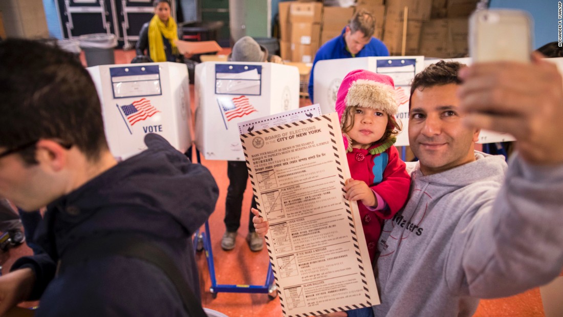 A man snaps a selfie with his child as he waits to vote in Brooklyn, New York.