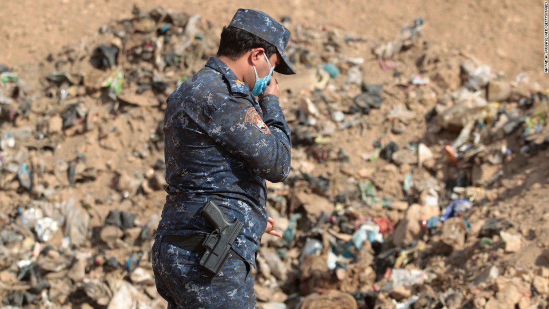 An Iraqi forces member investigates a mass grave that was discovered after coalition forces recaptured the area of Hamam al-Alil on Monday, November 7.