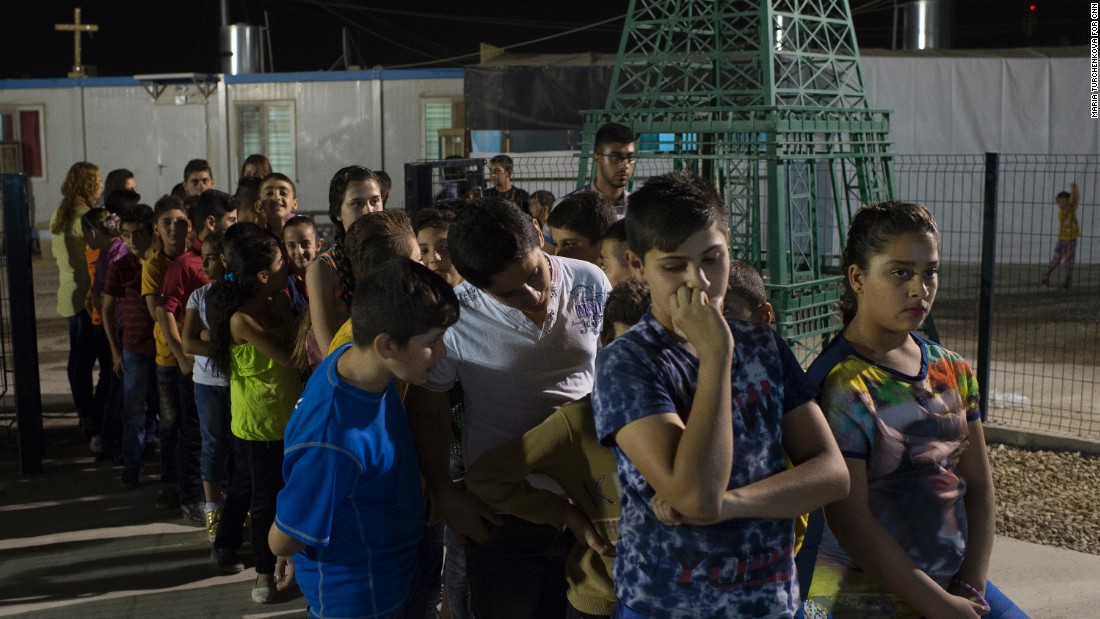 Young Iraqis wait for communion outside a church in&lt;strong&gt; &lt;/strong&gt;Irbil&#39;s Ashti camp. 