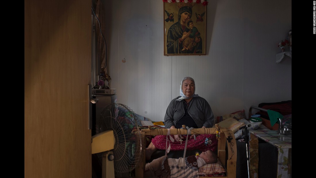 An elderly woman keeps watch over her great-granddaughter at Ashti. She and her family fled Qaraqosh, Iraq&#39;s largest Christian city, when ISIS fighters took it over in August 2014. 