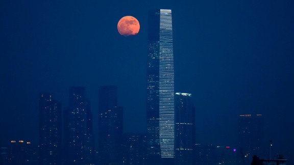 The moon rises over Victoria Harbour in Hong Kong on November 14. A supermoon occurs when the moon becomes full on the same days as its perigee, which is the point in the moon