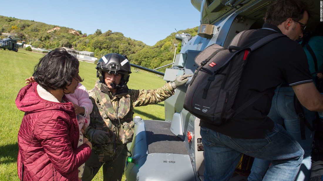 A member of the New Zealand Defence Force assists a family aboard a helicopter during evacuations of Kaikoura. The popular tourist destination on the South Island is home to more than 3,500 people.
