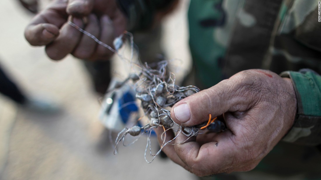 A Kurdish Peshmerga fighter holds part of a defused bomb planted by ISIS militants in Bashiqa, Iraq, on Friday, November 11.