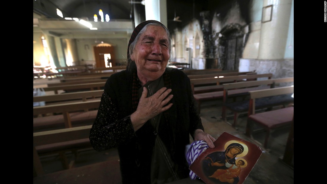 A woman cries Sunday, November 13, after seeing the St. Addai church that was damaged by ISIS fighters during their occupation of the Keramlis village.