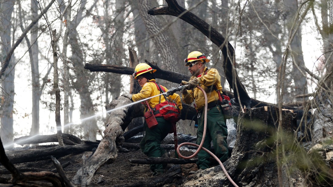 Firefighters Valarie Lopez and Mark Tabaez work to cool hot spots in Clayton on November 15. A number of the fires are being investigated as suspected arson, but weather conditions are also responsible for the fires.