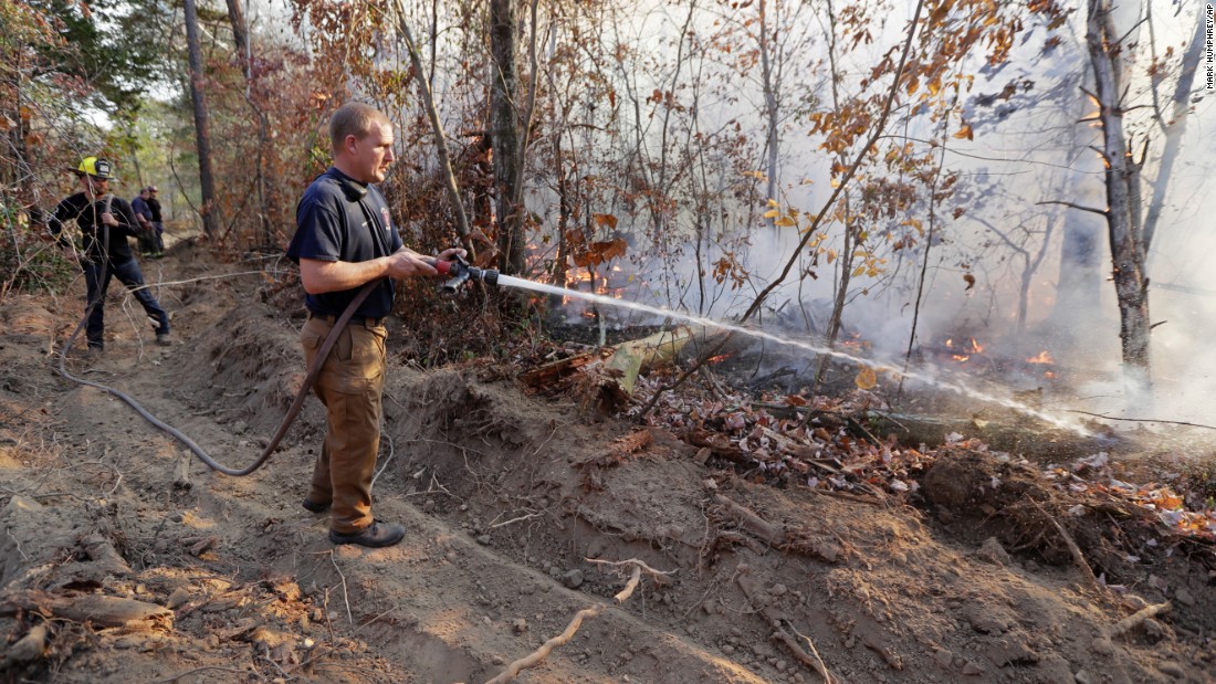 Assistant Fire Chief Brent Masey sprays water on a wildfire in Soddy-Daisy, Tennessee, on Thursday, November 10.