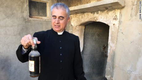 A bottle of wine is among the items Behnam Lalo was able to salvage from St. George Church in Bartella.