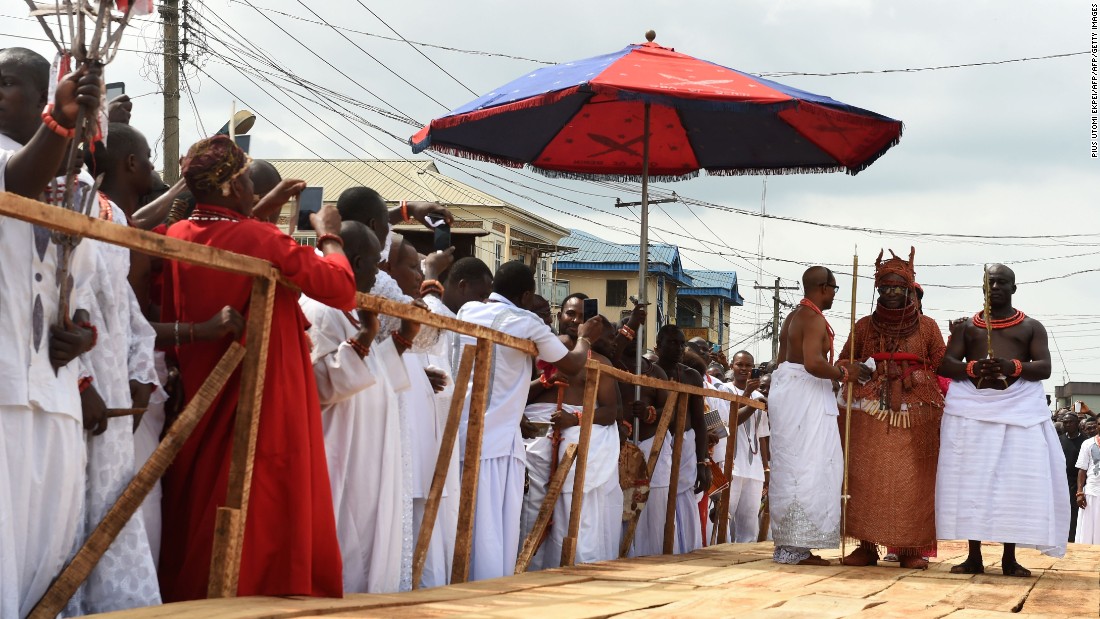 Newly crowned 40th Oba, or king, of the Benin kingdom, Oba Ewuare II , walks on a wooden bridge assisted by palace aides to perform the rite during his coronation. 