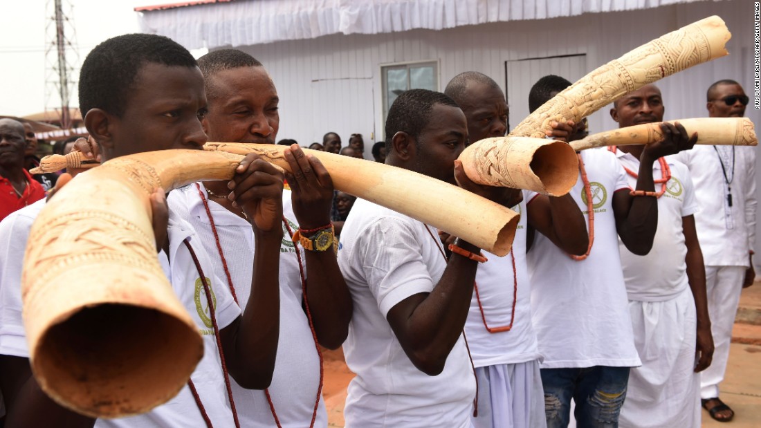 Royalist supporters blow in sculpt elephant tusks during the coronation ceremony.