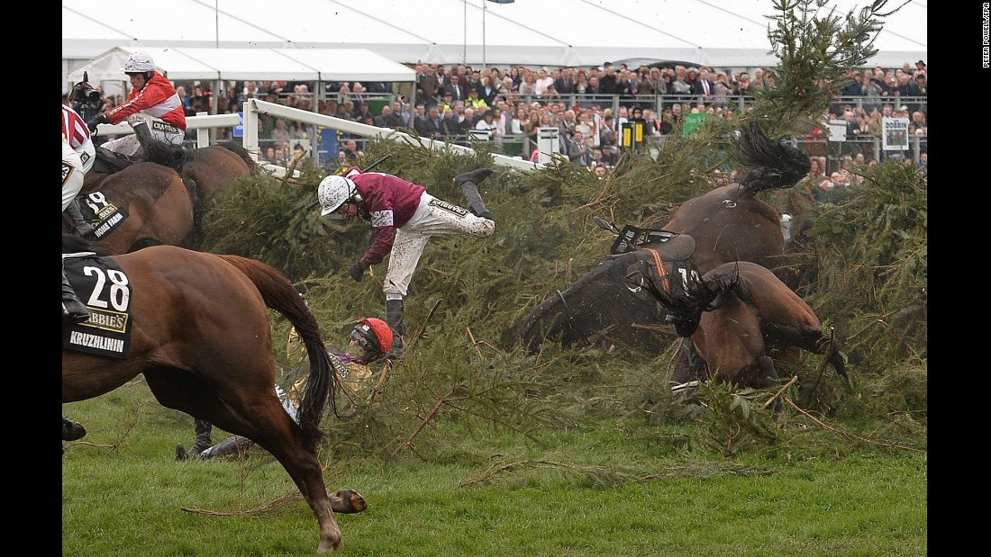 Horses and their jockeys fall over a fence Saturday, April 9, during the Grand National steeplechase in Liverpool, England.