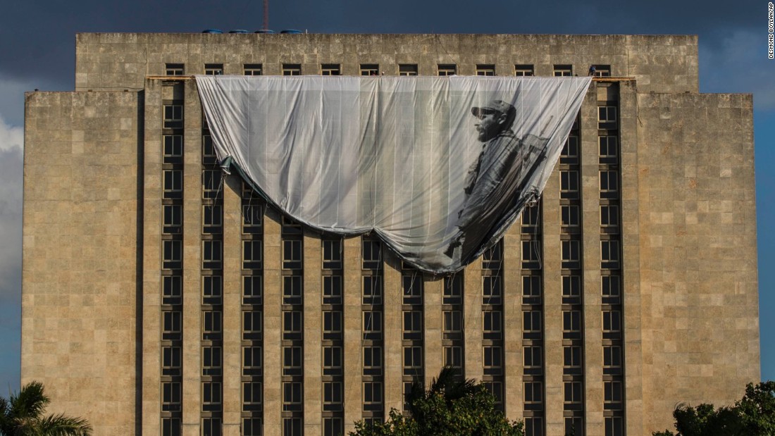 Workers hang a giant banner of a young Castro from the Cuban National Library in Havana on Sunday, November 27. 