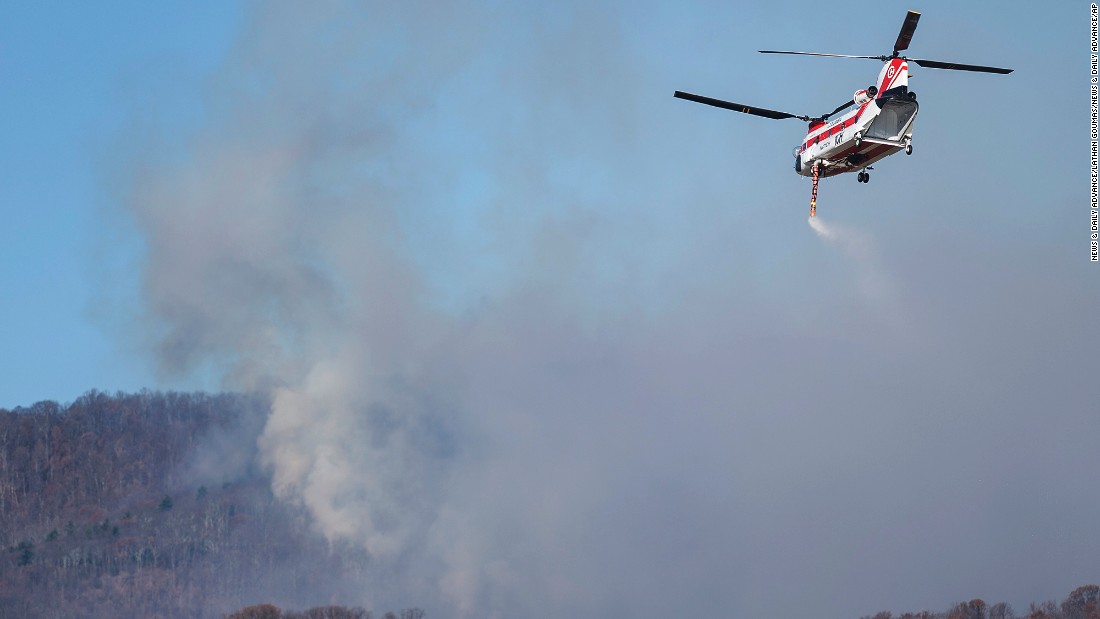 A helicopter picks up water from Thrasher Lake to help battle a wildfire in Amherst County, Virginia, on November 21.