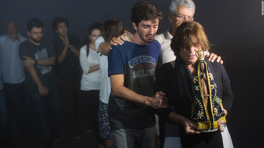Ana Maria holds a statue of Our Lady of Aparecida as she and her family mourn the loss of her son, journalist Guilherme Marques, during a ceremony in Rio de Janeiro on November 29.