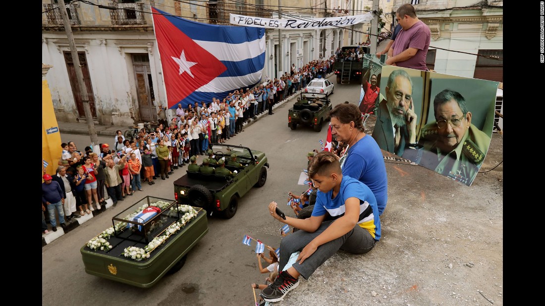 People watch from a rooftop as Castro&#39;s remains pass by in Santa Clara on December 1. Castro&#39;s ashes are on a four-day journey from Havana to Santiago de Cuba.