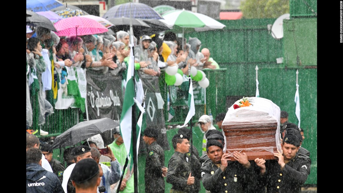 Soldiers carry the coffins of team members into Arena Conda stadium on December 3.