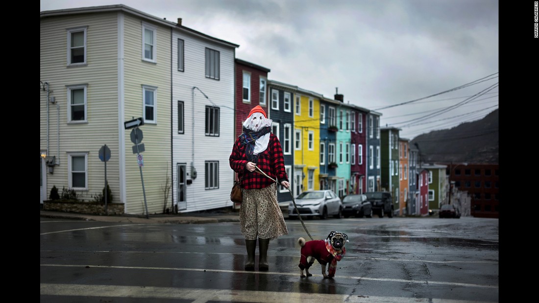 Sarah Ferguson and her dog Frank stand in traditional mummer dress in St. John&#39;s, Newfoundland. Mummering involves getting dressed up in disguise using anything one can scavenge -- curtains, lampshades, old clothing -- before going unannounced to neighbors&#39; homes for impromptu kitchen parties. The centuries-old Christmas tradition all but disappeared in Newfoundland and Labrador, but a new generation is starting to revive it, according to photographer Darren Calabrese.