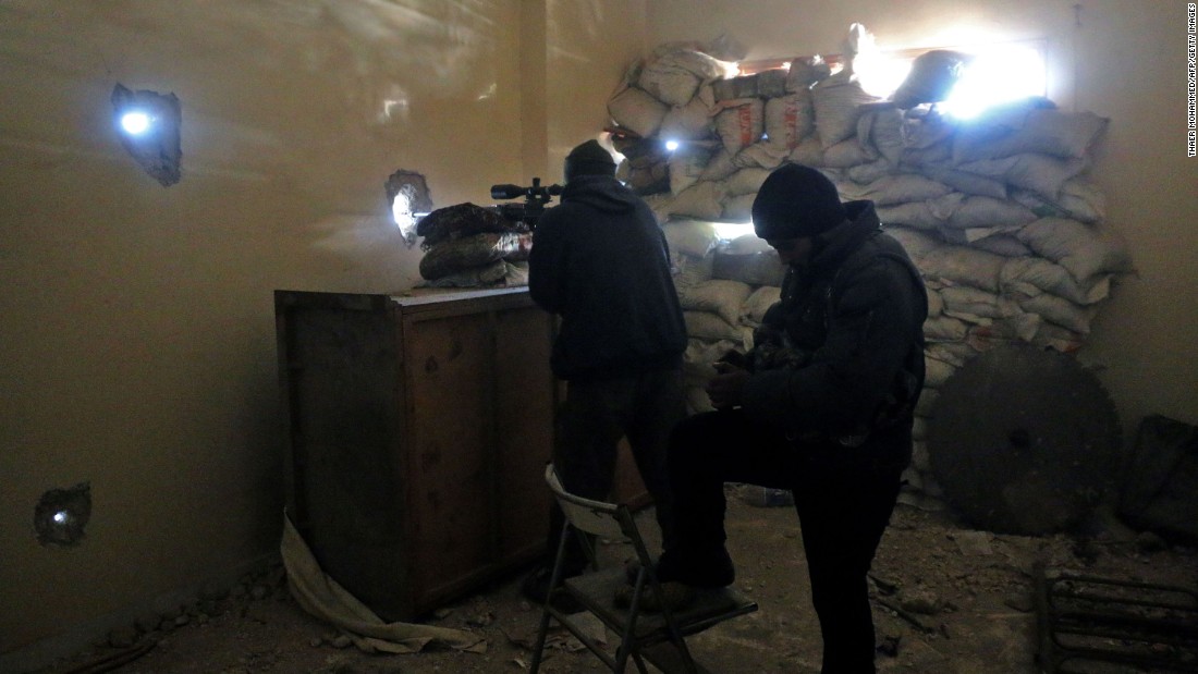 Rebel fighters take aim at pro-government positions in Aleppo on Friday, December 9.