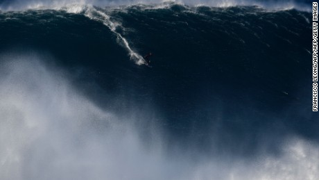 A surfer rides a wave off Praia do Norte near Nazare, central Portugal, on October 24, 2016.