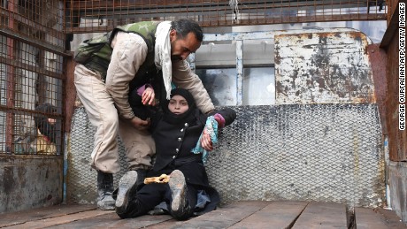 TOPSHOT - A wounded Syrian woman from the al-Sukari neighbourhood is helped onto the back of a truck as she flees during the ongoing government forces military operation to retake remaining rebel-held areas in the northern embattled city of Aleppo on December 14, 2016. 
Shelling and air strikes sent terrified residents running through the streets of Aleppo as a deal to evacuate rebel districts of the city was in danger of falling apart.

 / AFP / George OURFALIAN        (Photo credit should read GEORGE OURFALIAN/AFP/Getty Images)