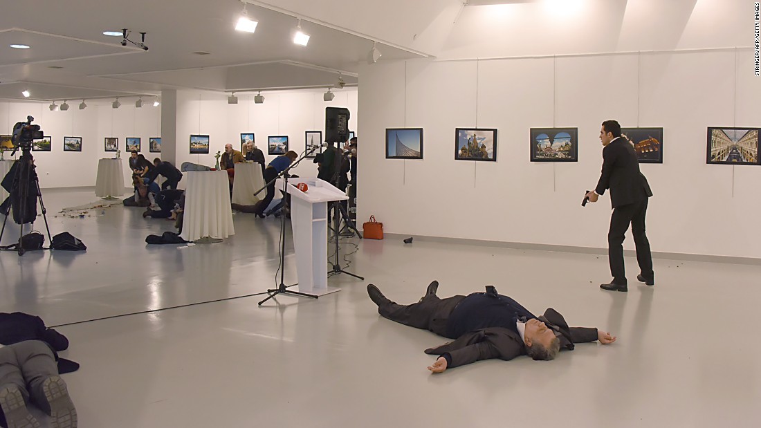Karlov&#39;s body lies on the floor as the gunman stands nearby. 