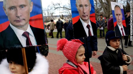 Children hold portraits of Putin during a rally to mark a Russian holiday -- Defender of the Fatherland day -- in the Crimean city of Sevastopol, on February 23, 2016.