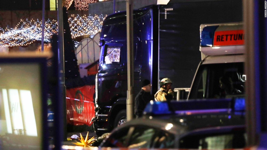 Police stand beside the damaged truck that crashed into the market.