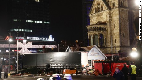 Policemen stand next to a truck that crashed into a Christmas market in Berlin, on December 19, 2016 killing at least one person and injuring at least 50 people.
Ambulances and police rushed to the scene after the driver drove up the pavement of the market in a central square popular with tourists less than a week before Christmas, in a scene reminiscent of the deadly truck attack in Nice.