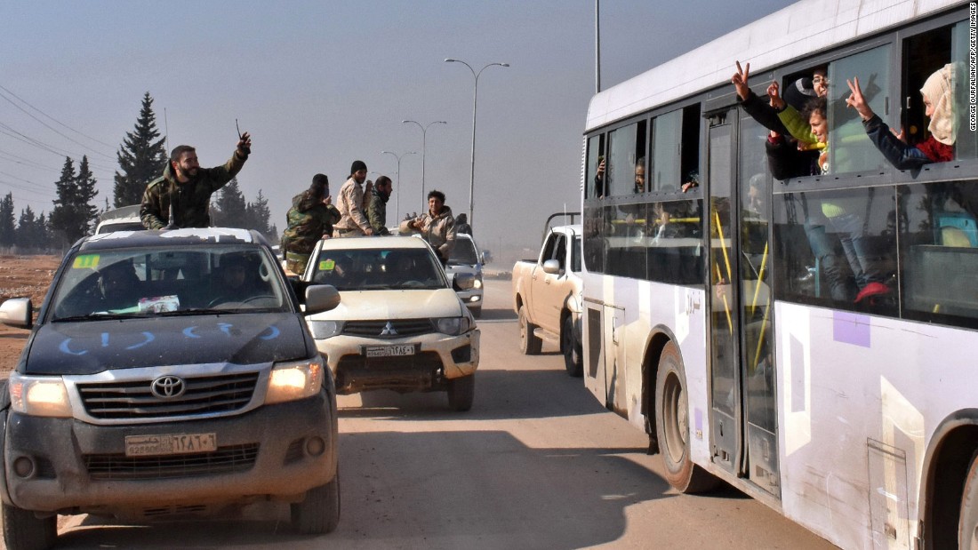 Syrian pro-government forces wave to evacuees from the villages of Foua and Kefraya on December 19. While people were being bused out of Aleppo, safe passage was also given to people in areas held or besieged by rebels, the Aleppo Media Center activist group said.