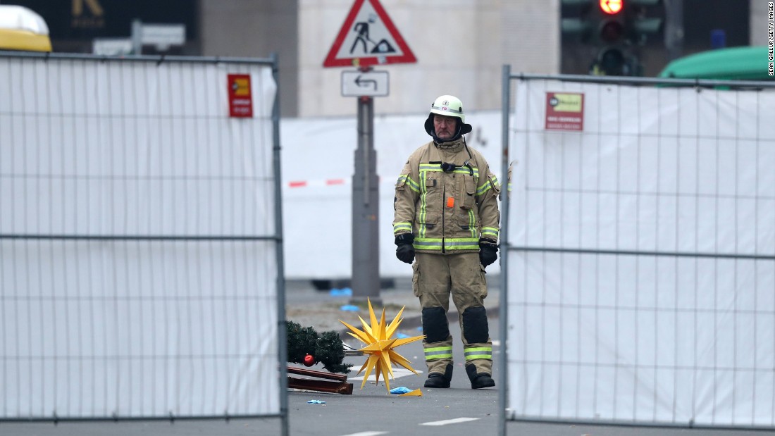 A rescue worker stands beside Christmas decorations that were scattered by the crash.