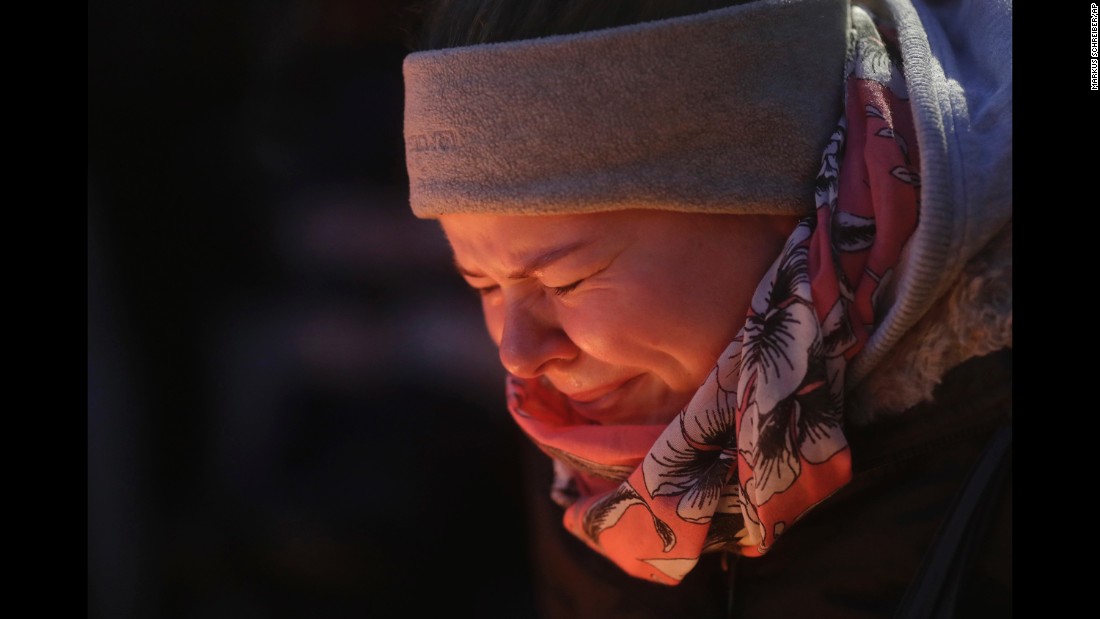 A woman is illuminated by candles as she cries in Berlin on December 20.