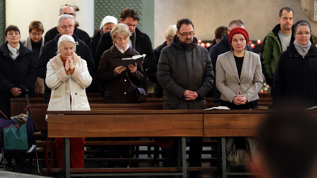 People attend a memorial service at St. Hedwig Cathedral in Berlin on December 20.