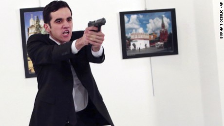 An unnamed gunman gestures after shooting the Russian Ambassador to Turkey, Andrei Karlov, at a photo gallery in Ankara, Turkey, Monday, Dec. 19, 2016. The Russian foreign ministry spokeswoman said he was hospitalized with a gunshot wound. (AP Photo/Burhan Ozbilici)