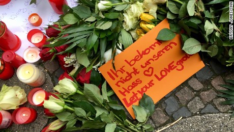 People leave tributes to the Berlin victims. One note reads, &quot;Let your love grow.&quot;