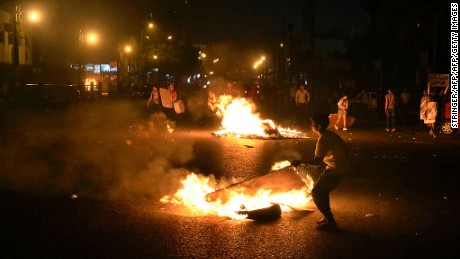 Egyptian anti-government  protesters walk through burning cardboard during clashes between the April 6 movement supporters and police outside the High Court on April 6, 2013 in Cairo.