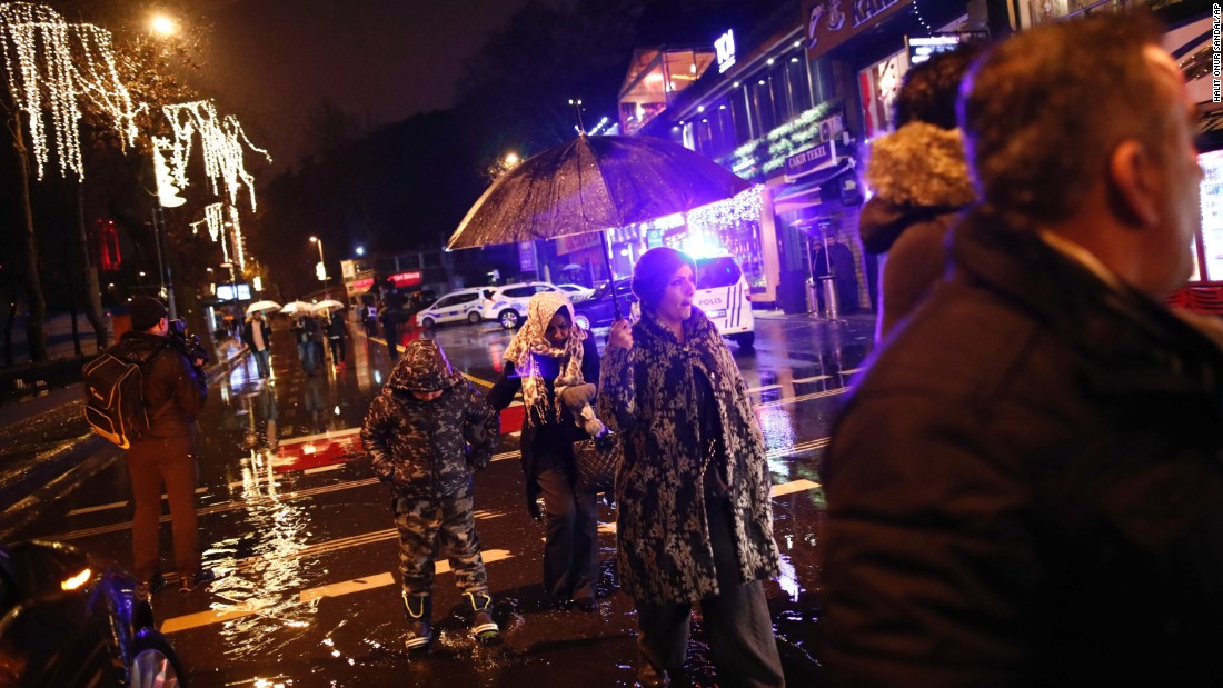 People walk in the rain near the scene of the attack.