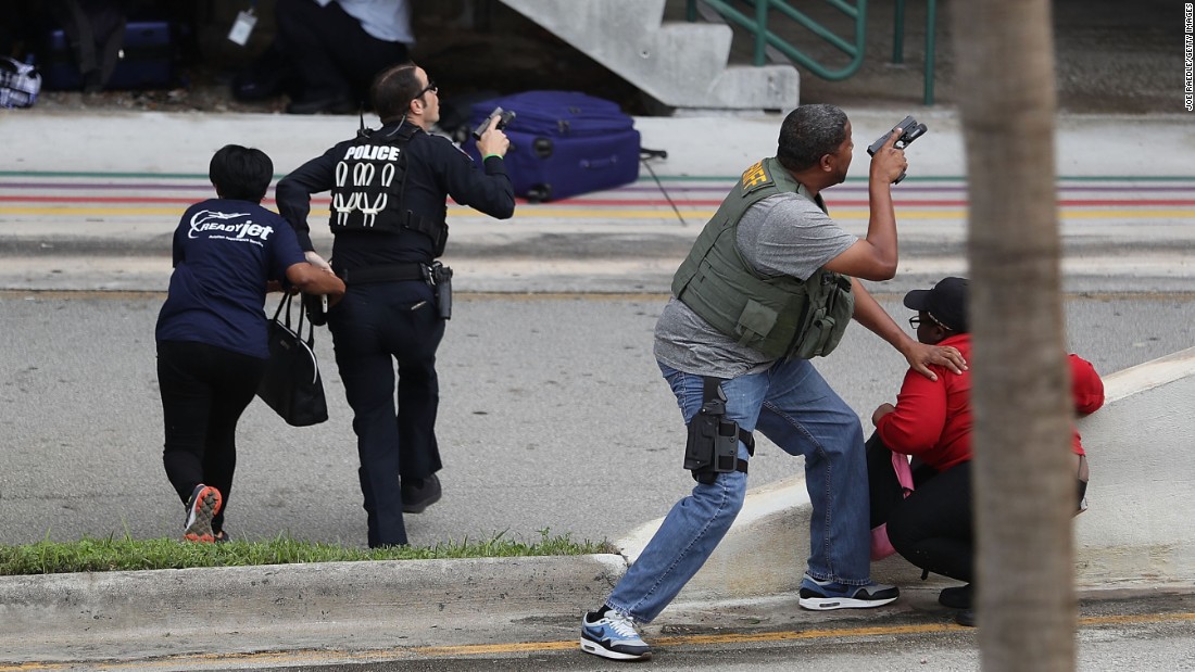 Police assist people seeking cover outside Terminal 2 at the Fort Lauderdale airport. 