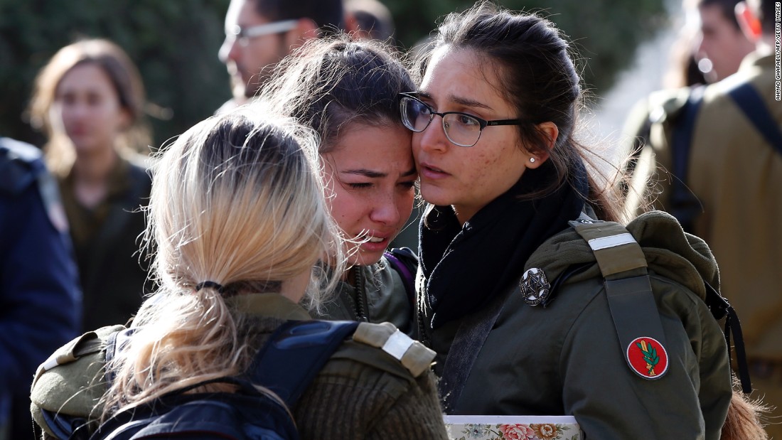 Israeli soldiers console each other at the site of the attack, which occurred on a popular promenade overlooking the walled Old City of Jerusalem. 