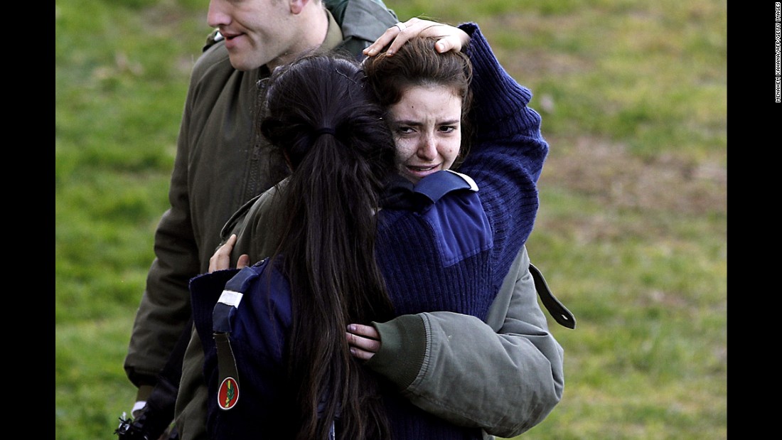 A distraught Israeli soldier is consoled at the site of Sunday&#39;s attack.