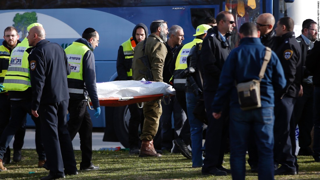 Israeli medics carry a covered body from the scene of the attack.