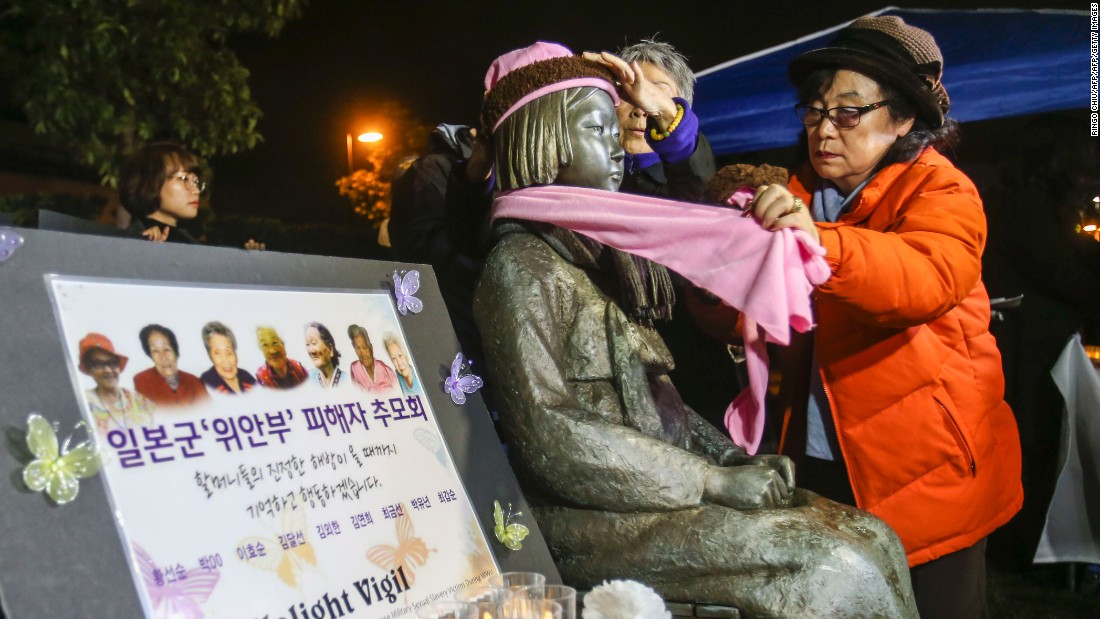 Supporters place a scarf and hat on the Glendale memorial statue during a candlelit vigil in January 2016. 