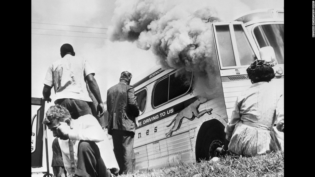Freedom Riders sit outside a bus after it was set on fire by a white mob in Anniston on May 14, 1961.
