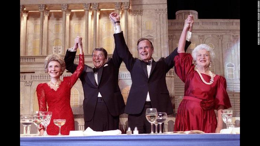 President Reagan and Vice President Bush, accompanied by their wives, join hands after Reagan endorsed Bush's run for the presidency during a dinner in Washington on May 11, 1988.